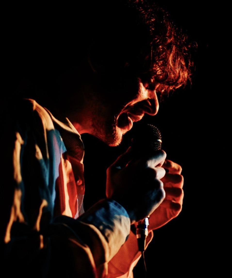 Cantante al microfono in luce rossa